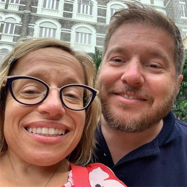 jen arnold and bill klein smiling selfie in front of a brick building