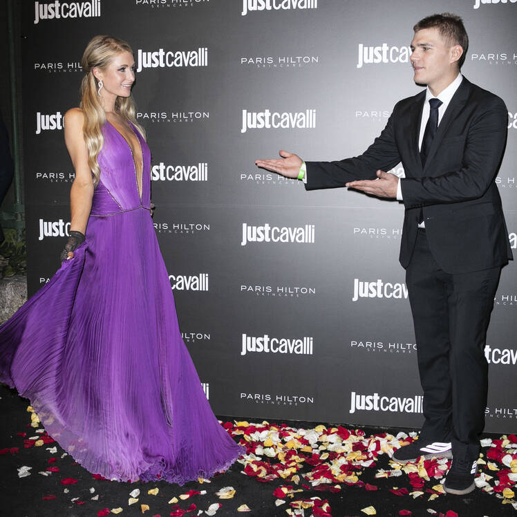 Paris Hilton is wearing a purple dress with Chris Zylka
