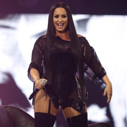 Demi Lovato wearing a black dress onstage