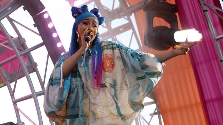 Cardi B Wearing Blue Hair With a Tie Dye Jacket on Stage
