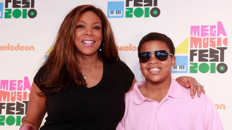 Wendy Williams Wearing a Black Shirt With Her Arm Around Her Son Kevin Jr. With a Pink Shirt on