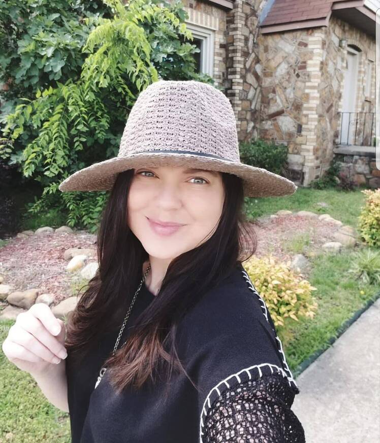 amy duggar smiling at camera with hat on