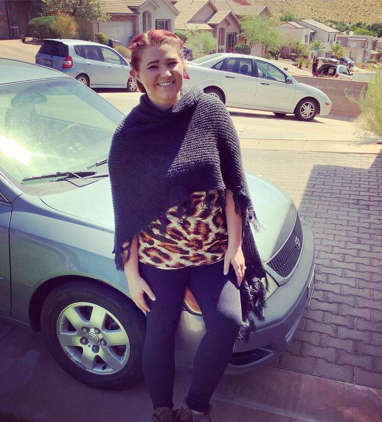 mykelti brown posing in front of a car