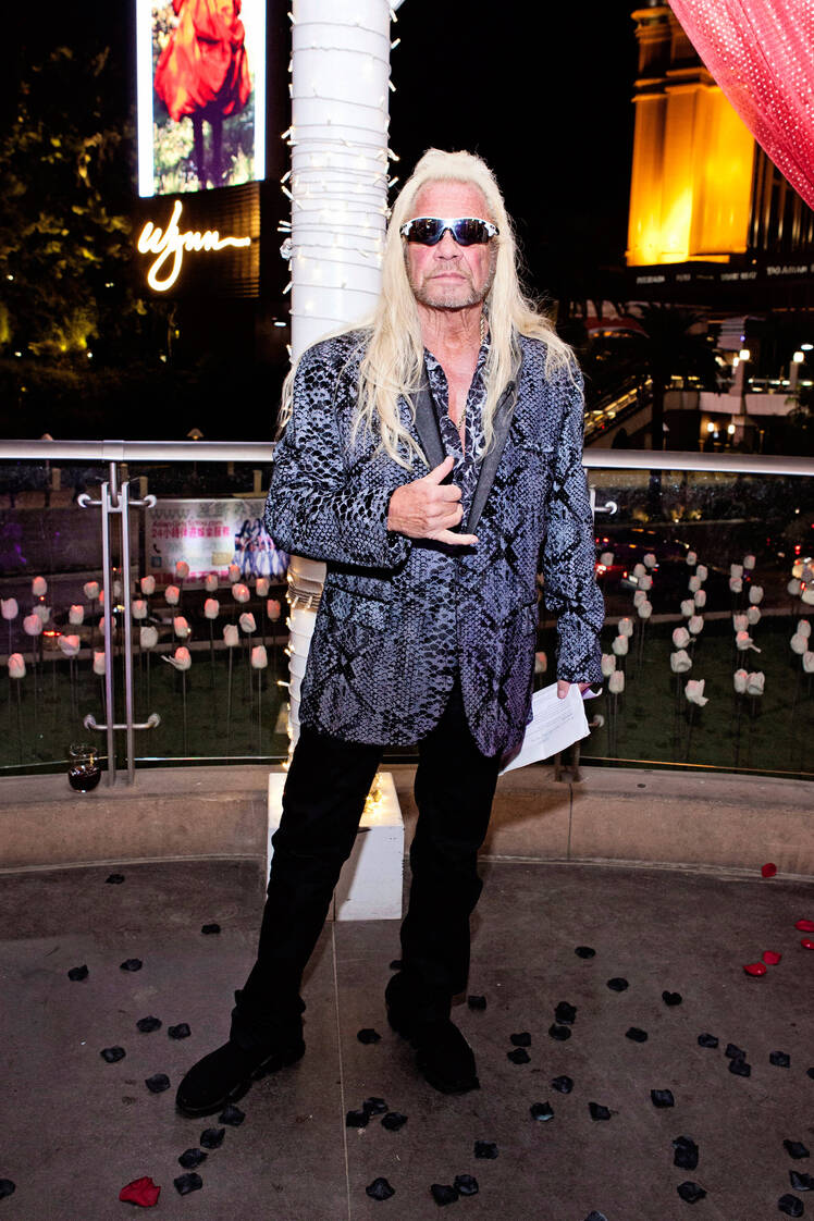 duane dog chapman looks sharp in black slacks and a blue and black snakeskin suit jacket with matching button down shirt while officiated his dog's most wanted costar's wedding in las vegas