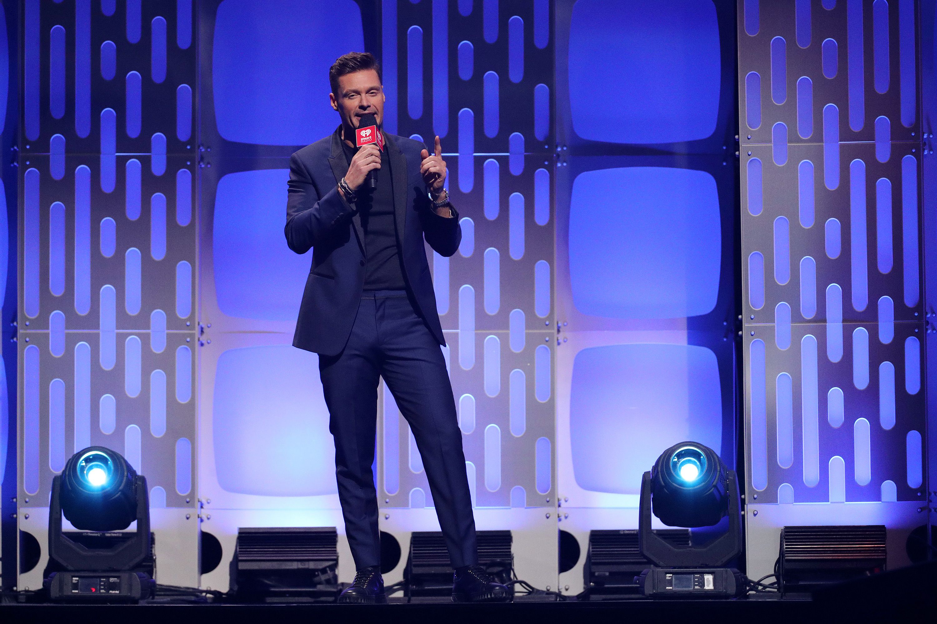 Ryan Seacrest mit einem Mikrofon auf der Bühne