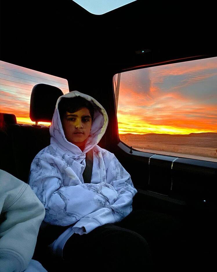 Mason Disick Sits in a Car Wearing a White Striped Hoodie