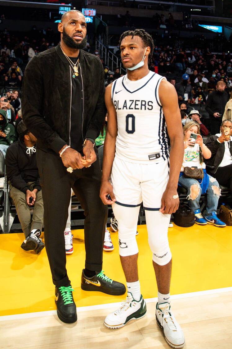 Lebron James standing next to his son Lebron James Bronny Jr. on the basketball court